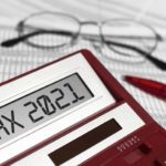 Word Tax 2021 on calculator. Glasses, pen and the calculator on documents. The concept of financial stability,Income Statement